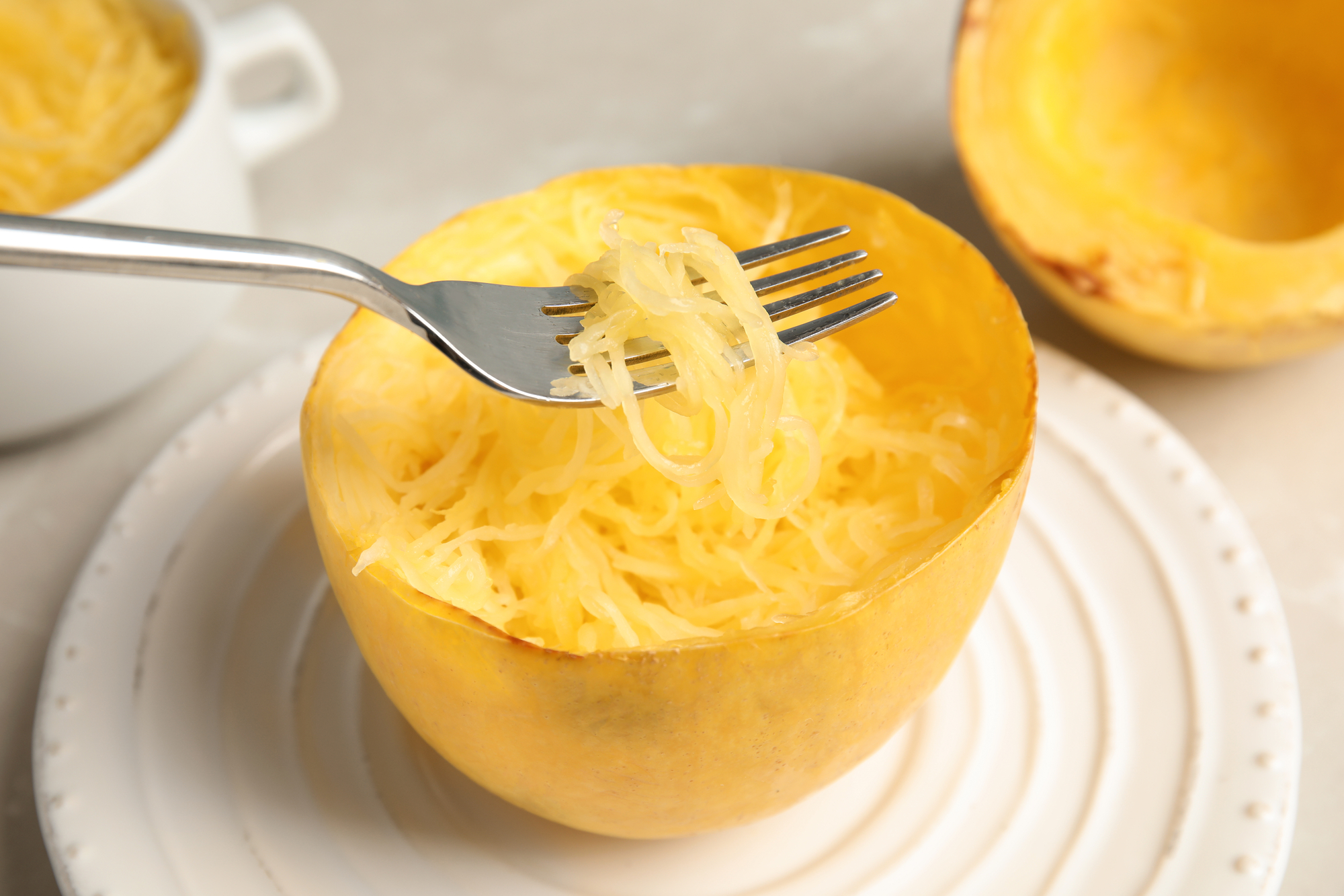 How to cut spaghetti squash - half cut horizontally with longer noodles on a fork